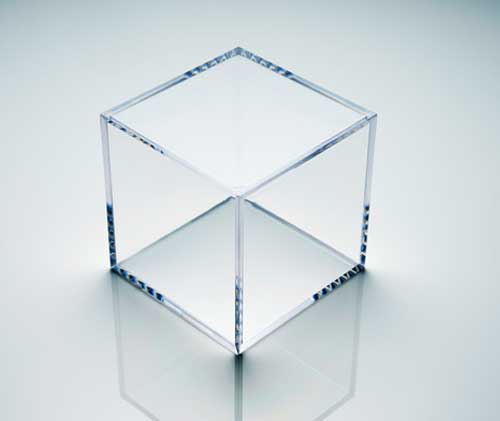Clear acrylic display cube on a reflective white surface