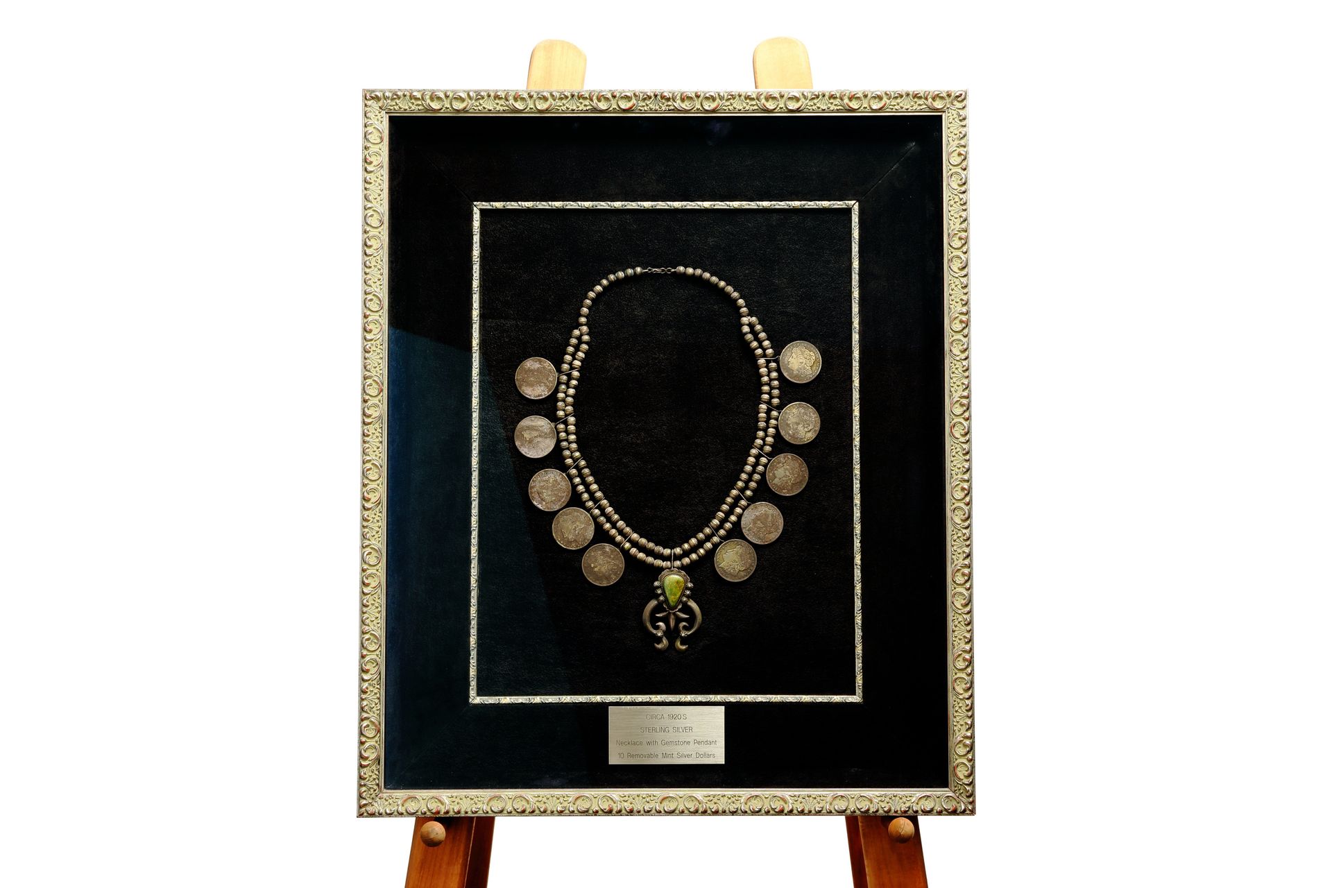 Sterling silver necklace with ten removable mint silver dollar coins, circa 1920s, preserved in a museum-style shadow box